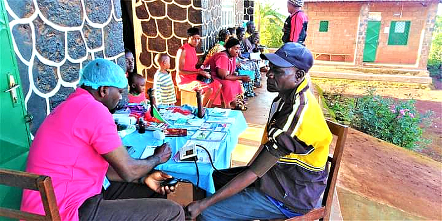 The Founder/CEO of Michael GG Foundation personally conducts a blood pressure screening during a community health outreach campaign in Baligham, Cameroon, providing free, on-site healthcare access to residents.